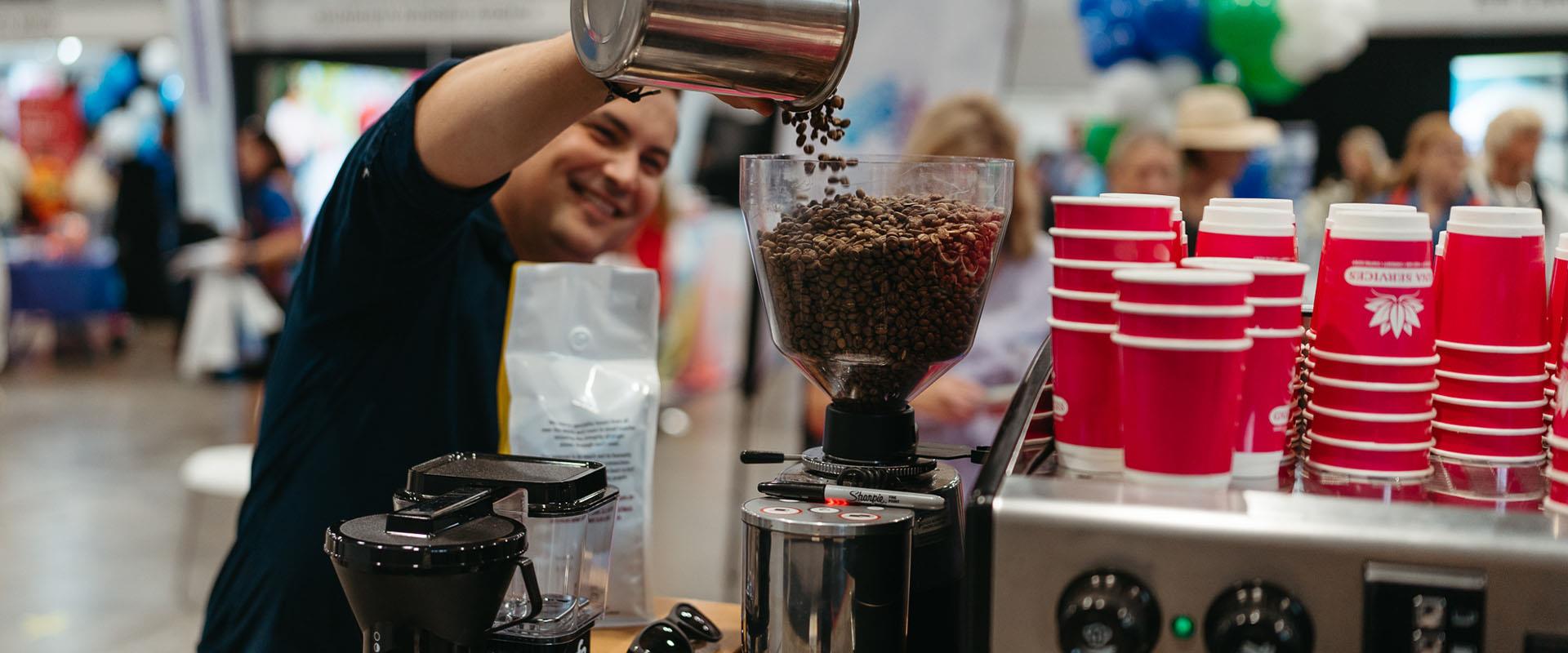 barista pouring coffee beans into machine